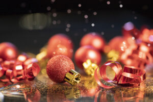 Red Christmas balls over sparkling holiday background. Magic holiday lights. Merry Christmas and a Happy New Year